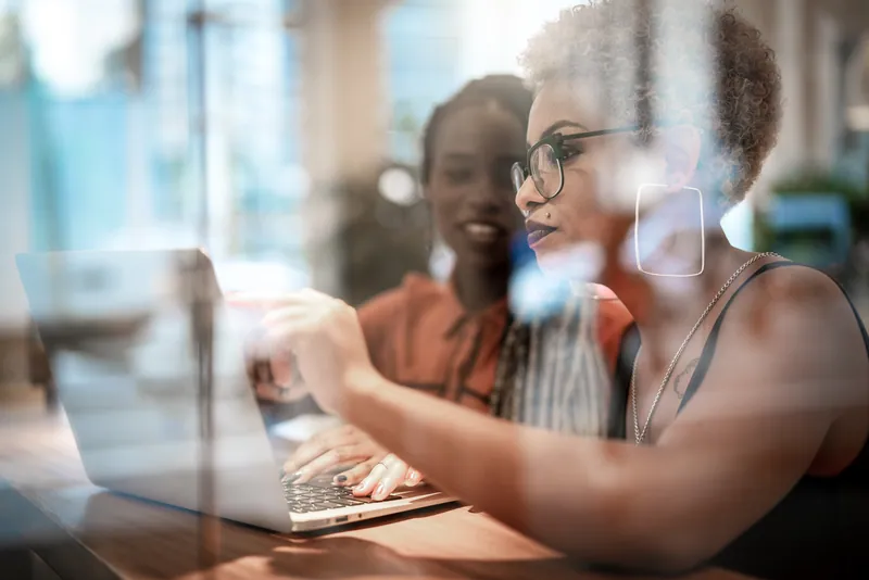 Duas mulheres conversando em reunião de trabalho